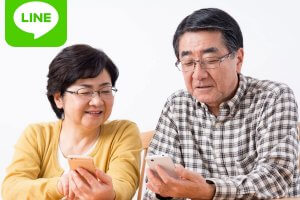 スマホでLINEする年配夫婦